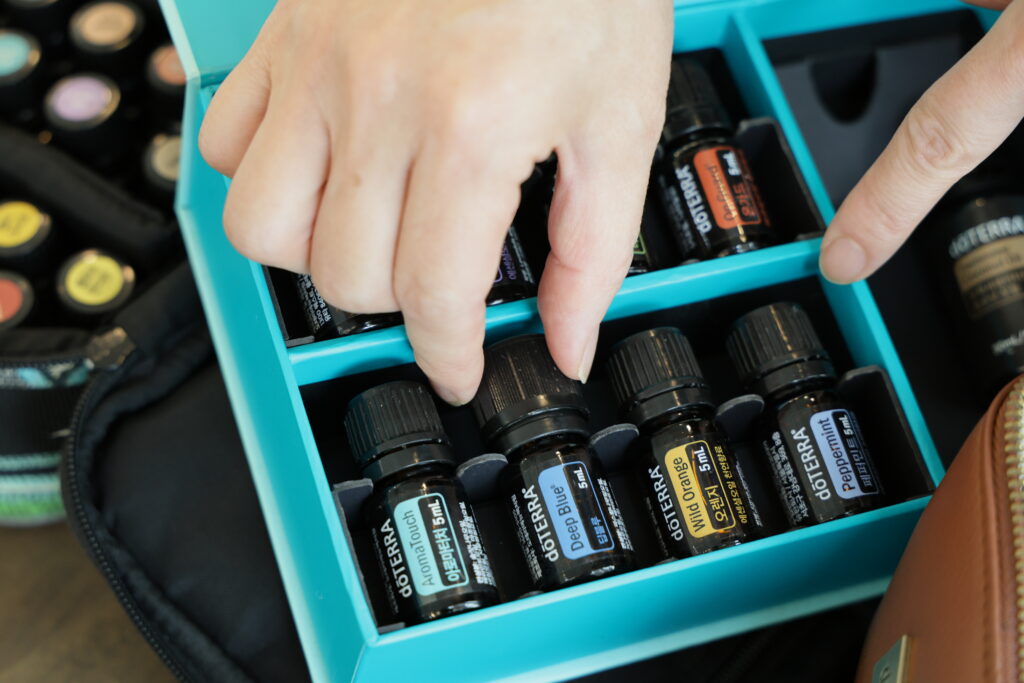 지담테라피 아로마 두피케어의 필요한 오일이 펼쳐져 있고 한 손으로 오일을 선택하고 있습니다.